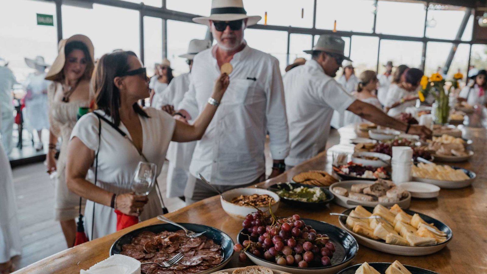 Group of friends enjoying an all-inclusive wine tour in Valle de Guadalupe at sunset with gourmet food.