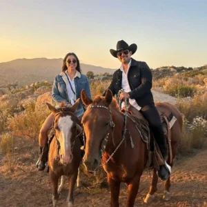 couple riding horse in valle de guadalupe at sunset