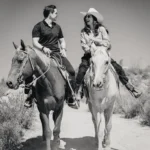 Jinetes a caballo en un sendero rocoso con vista a los viñedos del Valle de Guadalupe, Baja California