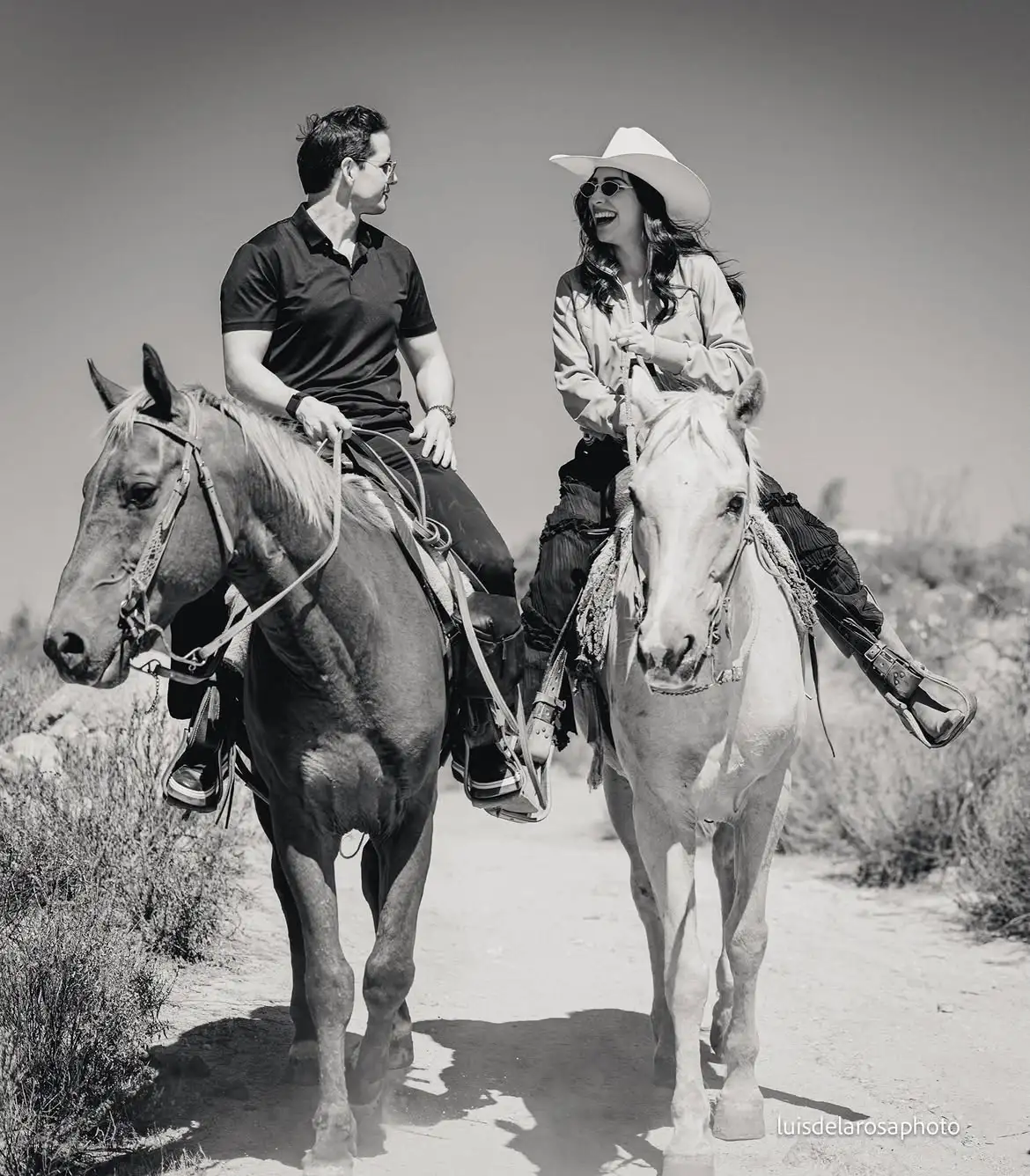 Jinetes a caballo en un sendero rocoso con vista a los viñedos del Valle de Guadalupe, Baja California